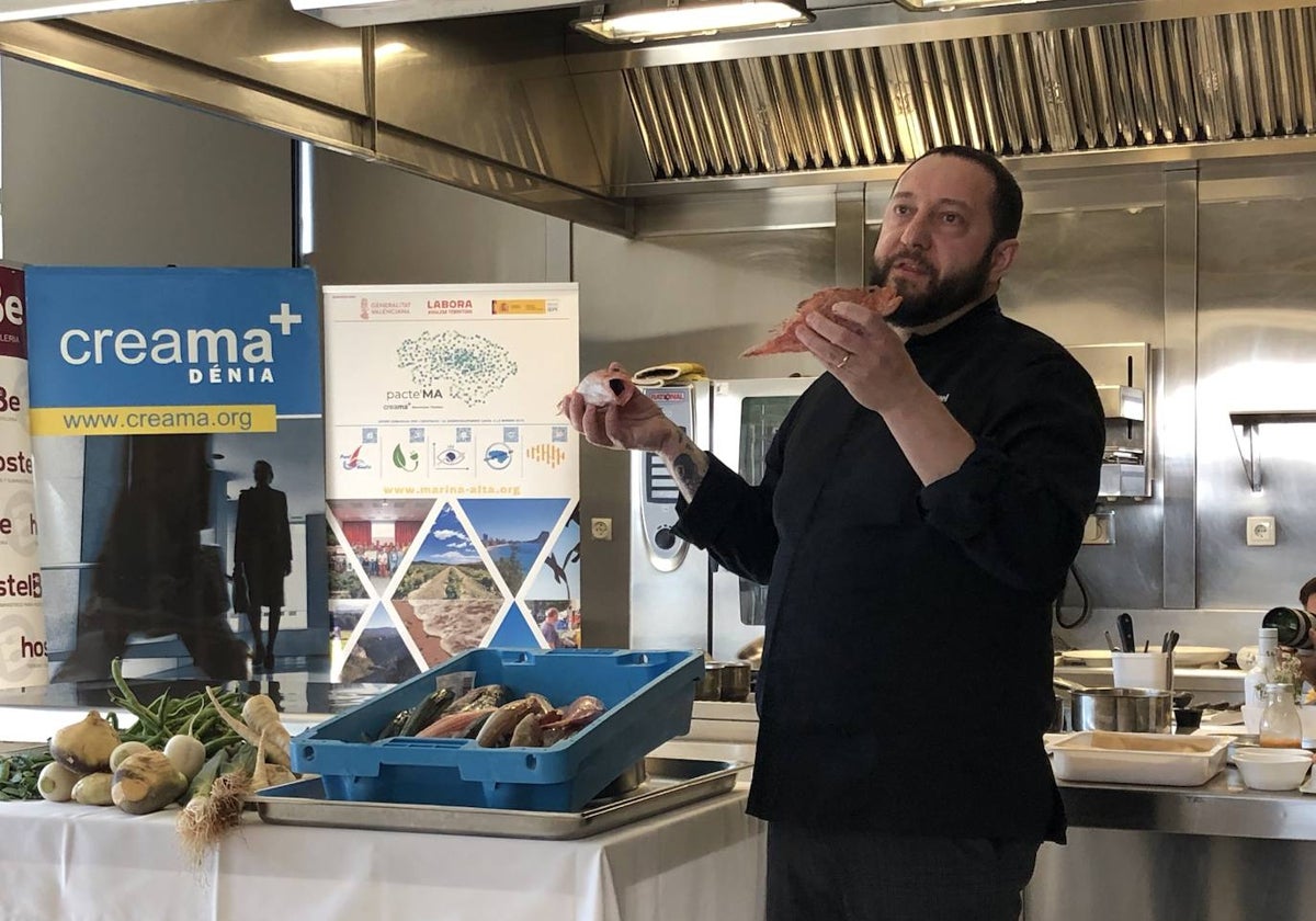 El chef José Manuel López mostrando dos pescados.