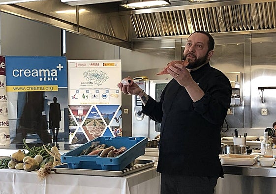 El chef José Manuel López mostrando dos pescados.