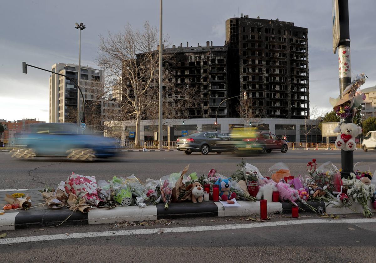 Flores en recuerdo a las víctimas junto al edificio incendiado de Campanar.