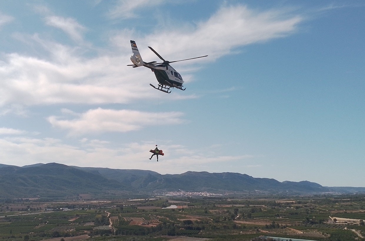 Imagen principal - Arriba, rescate con herido inmovilizado en camilla. Abajo a la izquerda, rescate de escalador en vertical y a la derecha, equpamiento de los agentes del GREIM.