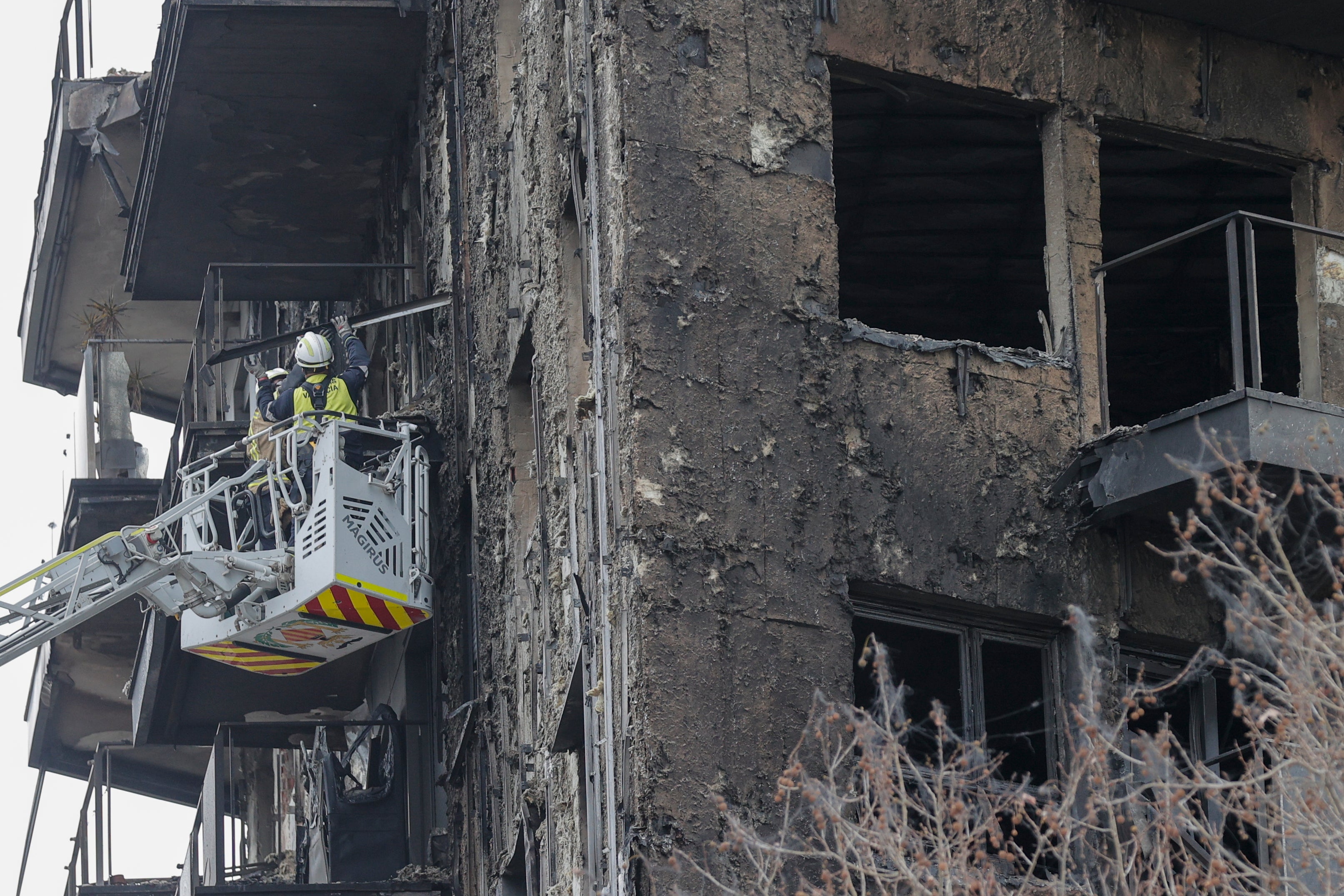 Los bomberos sanean parte de la fachada siniestrada en el edificio de Campanar.