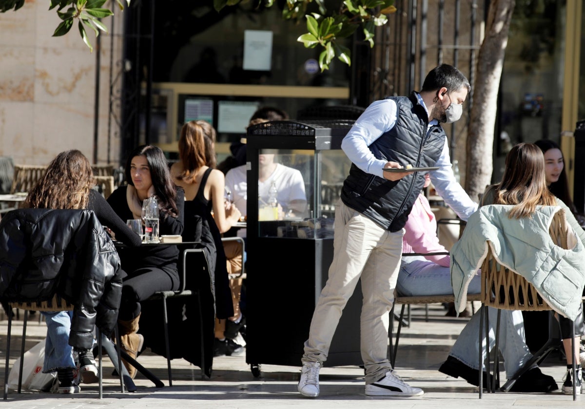 Un camarero trabaja en la terraza de un bar en Valencia.