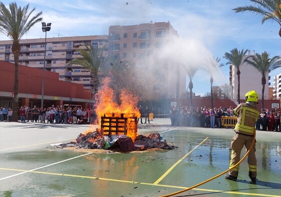 Un bombero controla la cremà de una falla escolar.