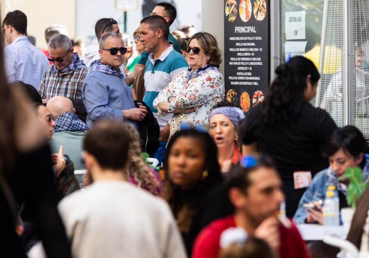 Varias personas esperan para comer en una terraza del centro de Valencia estas Fallas.