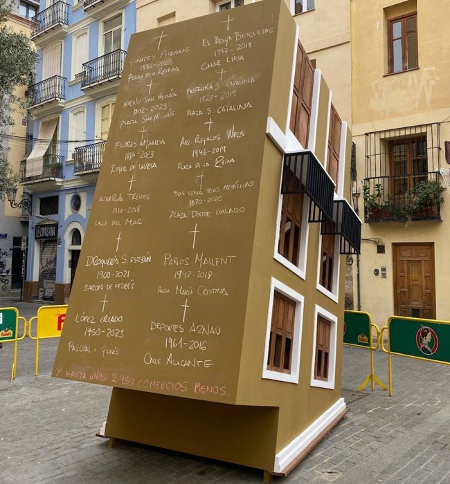 El monumento que retrata un edificio del revés que muestra en uno de sus muros el nombre de las tiendas desaparecidas.