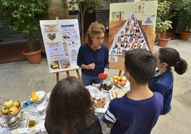 Una monitora da pautas a un grupo de alumnos sobre la dieta mediterránea.