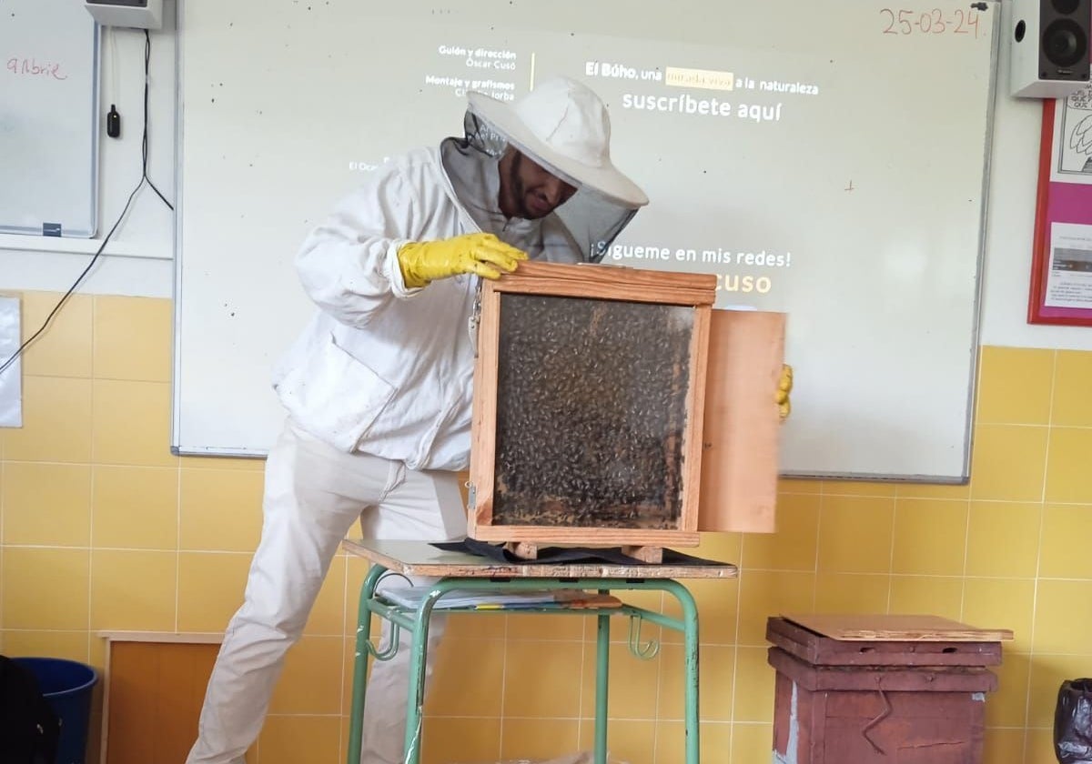 El apicultor muestra en clase uno de los panales de la colmena.