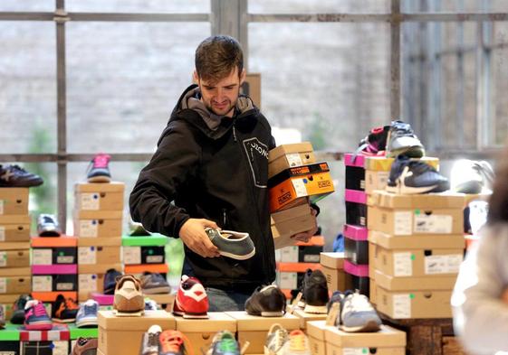 Un cliente observa unas zapatillas en un 'market' de calzado en Ruzafa.