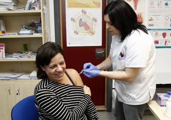 Una sanitaria vacuna de la tosferina a una mujer embarazada.