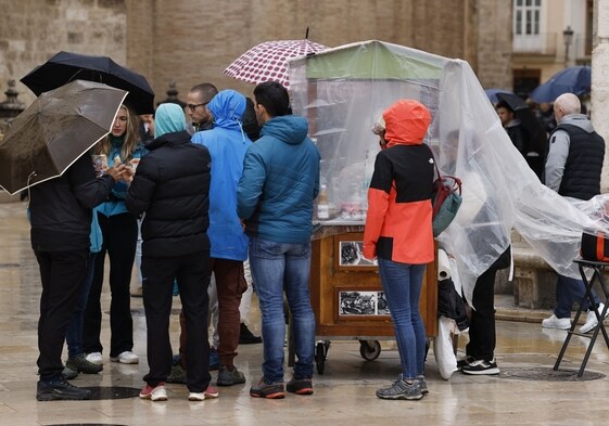 Viandantes se protegen de la lluvia caída en Valencia en Semana Santa.