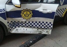 El coche de la Policía Local con daños en la puerta del conductor.
