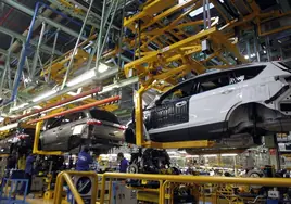 Varios trabajadores de la planta de Ford de Almussafes, en plena cadena de montaje de varios vehículos