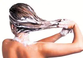 Una mujer lavándose el cabello.