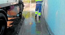 Trabajos de limpieza y baldeo en una calle de l'Eliana.