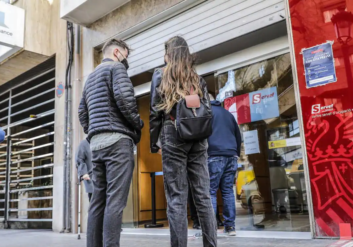 Dos jóvenes en la cola del paro.