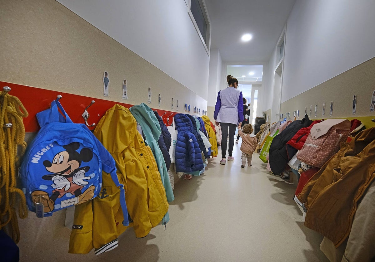 Una educadora acompaña a una alumna en una escuela infantil.