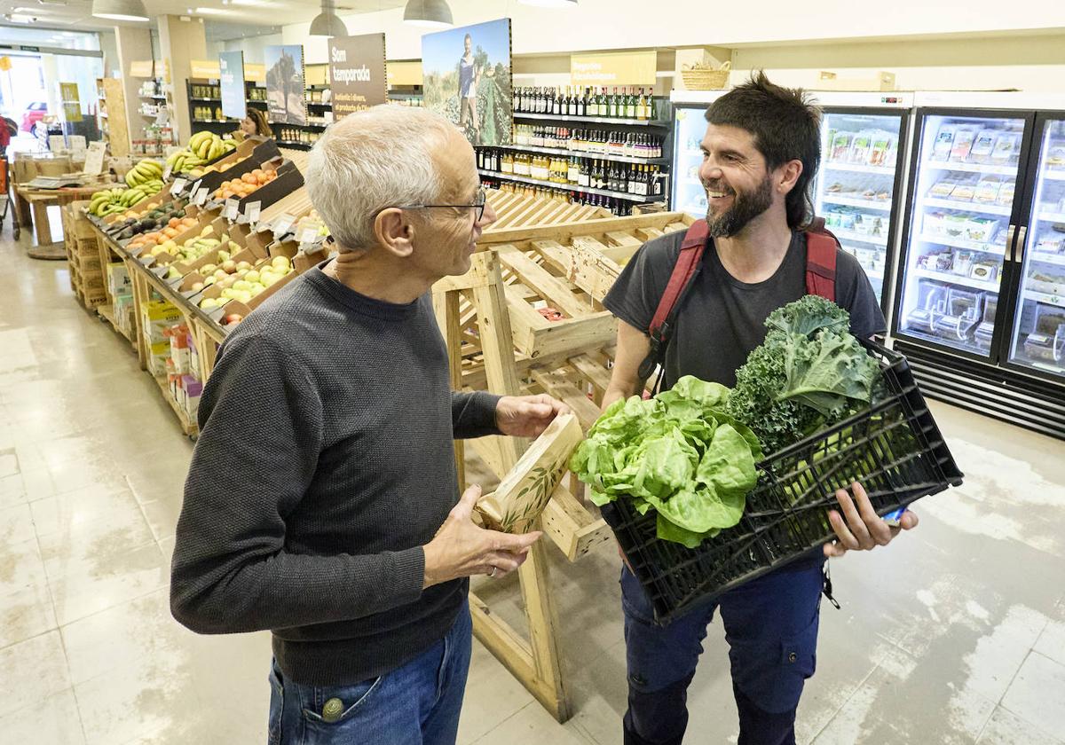 Paco, socio de la cooperativa, charla con Dani, un productor que acaba de llevar productos cultivados en sus tierras en La Pobla de Vallbona.