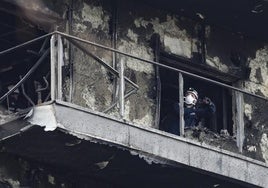 Un investigador inspecciona uno de los balcones destruidos por el fuego.