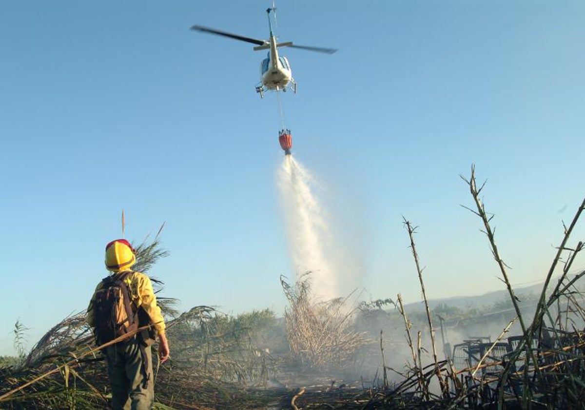 Un bombero presencia la descarga de la avioneta en un incendio.