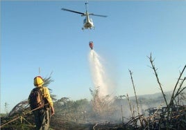 Un bombero presencia la descarga de la avioneta en un incendio.