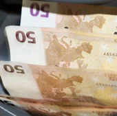 Una máquina cuenta y clasifica billetes de cincuenta euros en un banco.