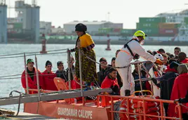 Una mujer desciende de una barca de rescaste tras interceptar una patera llegada hace unos días a Canarias.
