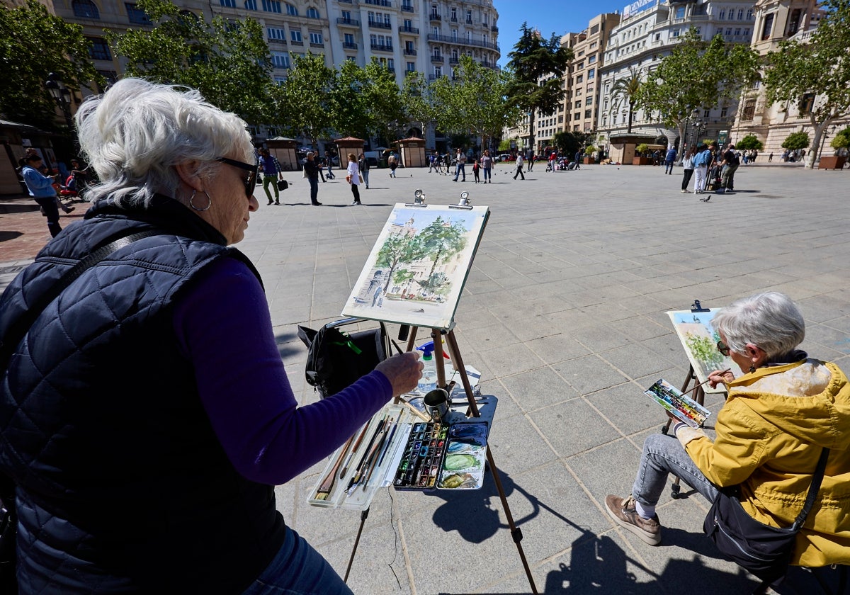 Una pareja de acuarelistas, en la plaza del Ayuntamiento.