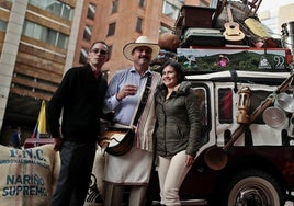 Dos personas posando junto a el personaje «Juan Valdez».