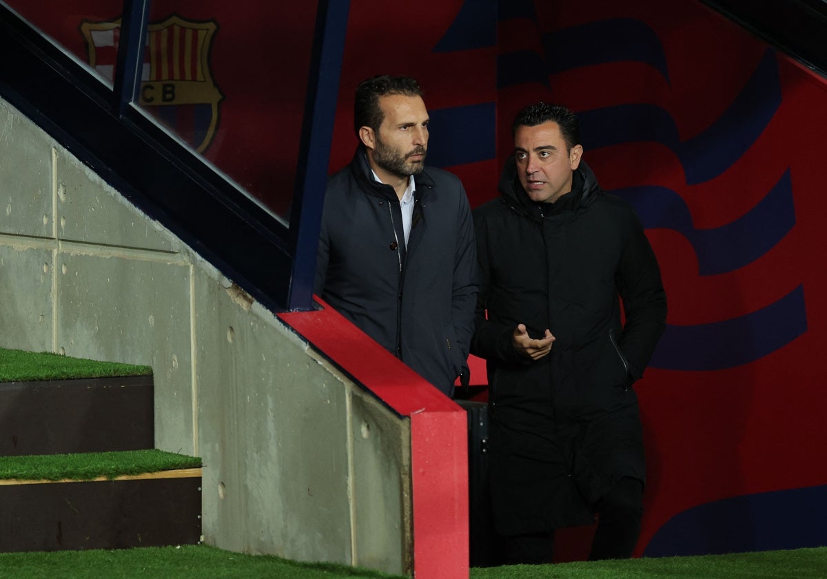 Rubén Baraja charla con Xavi Hernández antes del encuentro en Montjuic.