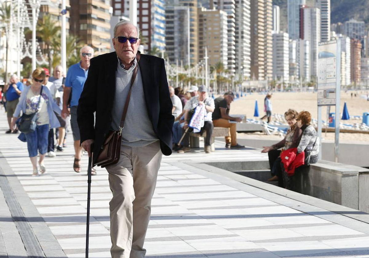 Un jubilado paseando en la playa.