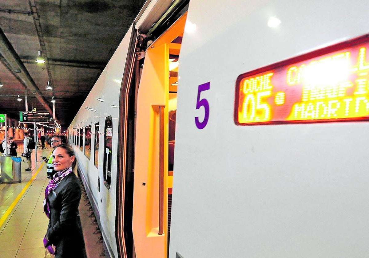 Unas azafatas aguardan junto a un AVE de Renfe.