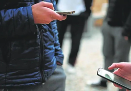 Dos adolescentes con su teléfono móvil.