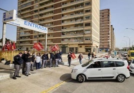 Un usuario se dispone a pasar la inspección de su vehículo ante las protestas de los trabajadores en la estación de Campanar.