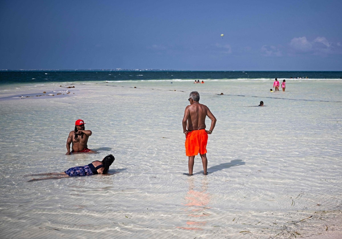 Varios bañistas disfrutan de una playa en Cancún.