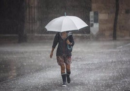 Una mujer se refugia de la lluvia en una imagen de archivo.