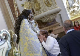 Una mujer da un emotivo beso a la Virgen de los Desamparados.