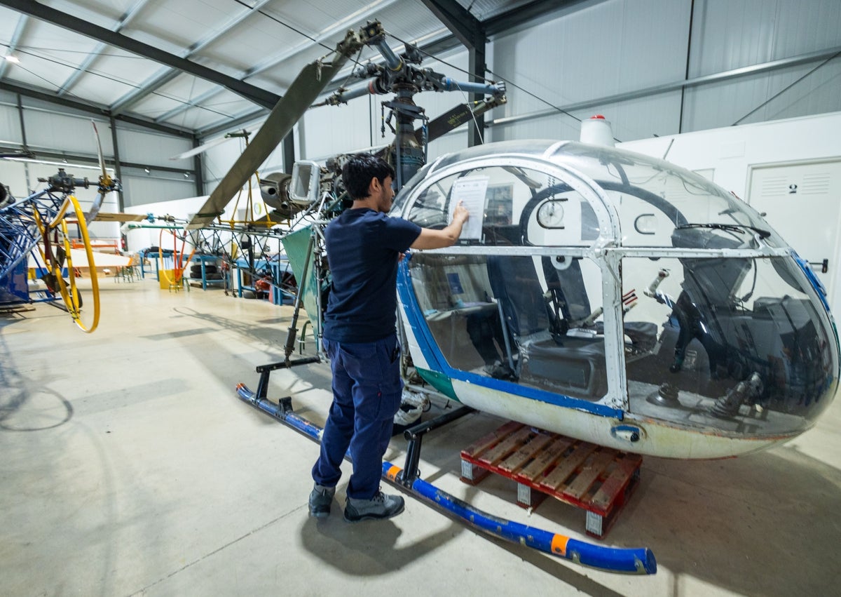 Imagen secundaria 1 - Una pieza desmontada de uno de los aviones, un alumno de los grados de FP en un helicóptero y uno de los empleados del proyecto aeroespacial Arkadia.