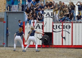 Al alimón, Paula y Sara, esperan la vaca soltada por las peñistas de ACT Vaques i Dones.