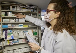 Una farmacéutica señala los medicamentos que escasean.