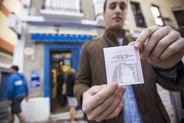 Un joven muestra un boleto del sorteo del Euromillón Imagen de archivo.