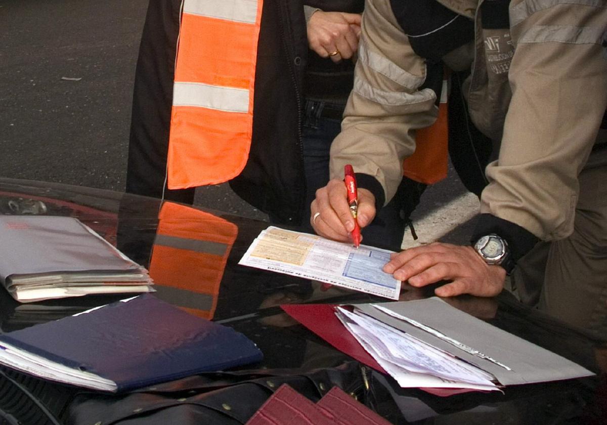 Implicados en una colisión múltiple firman los papeles del seguro tras el accidente, en una imagen de archivo.