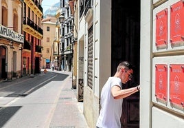 Un joven, en el portal de un edificio de viviendas turísticas.