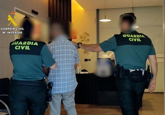 Agentes de la Guardia Civil custodian al detenido.