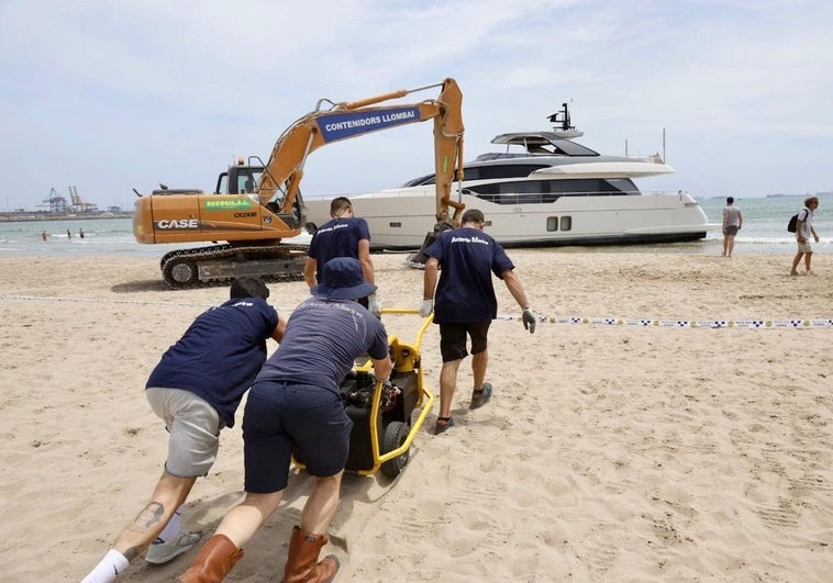 Una excavadora empieza a retirar la arena de la playa de Pinedo.