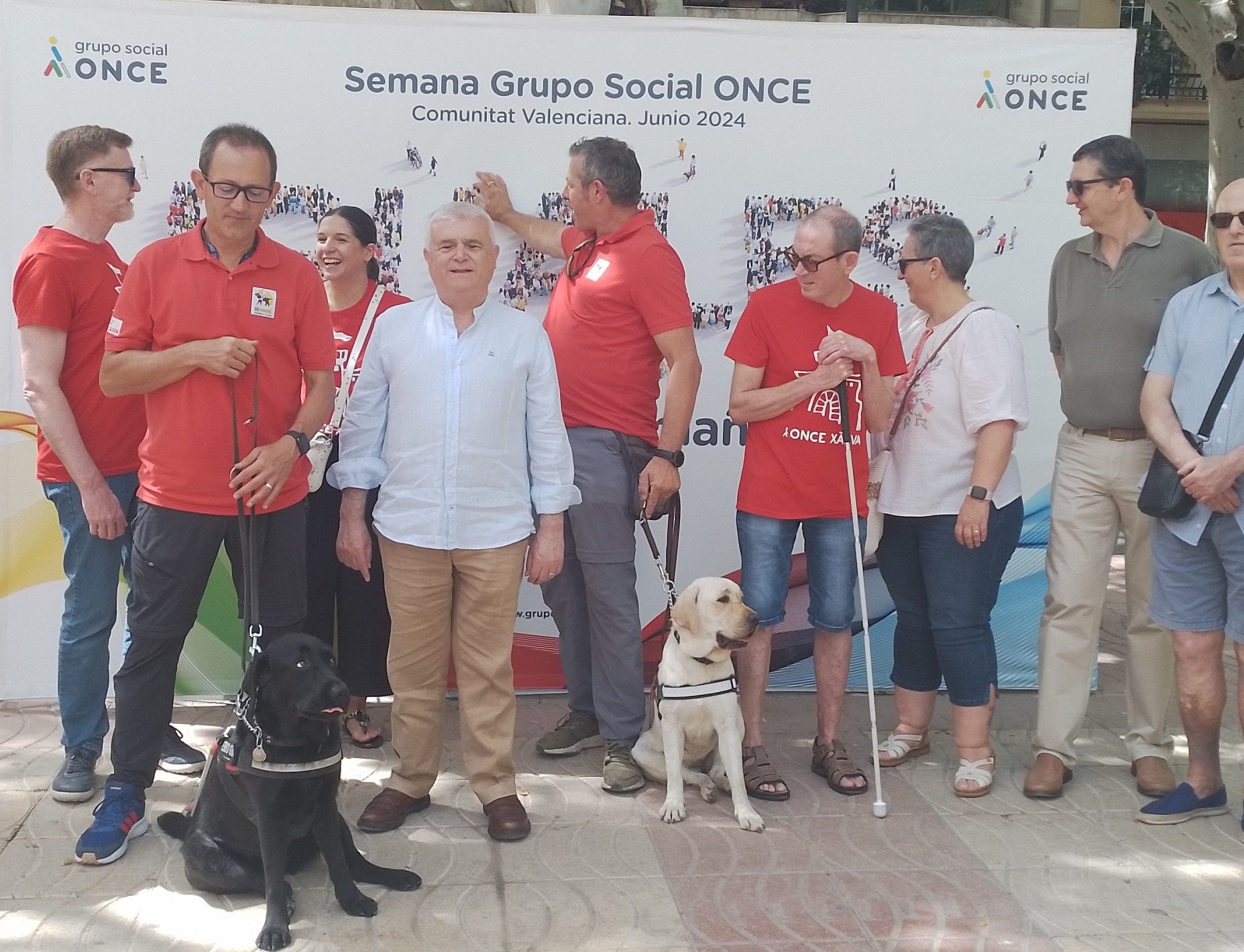 Enrique Llin, junto a los dos perros guía que han participado, y miembros de la ONCE.