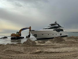 Excavadora, cable y operarios, en el segundo intento frustrado para desencallar el yate.