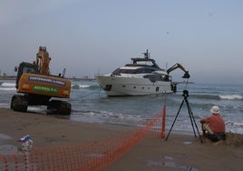 Una excavadora tira del barco para intentar desencallarlo, este sábado.