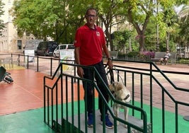 Uno de los perros guía ayudando a bajar las escaleras con uno de los adiestradors.