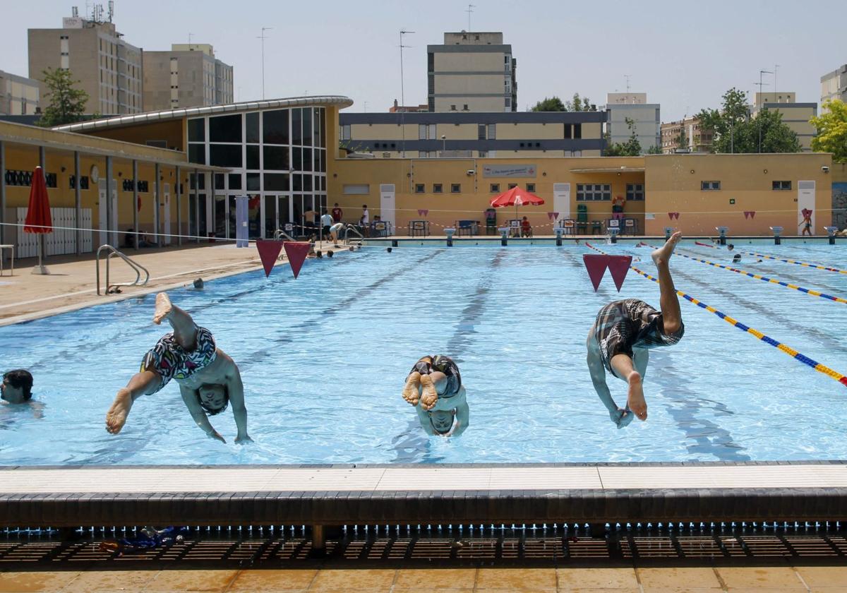 Un grupo de chicos saltando de cabeza a la piscina del Parque del Oeste.