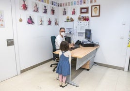 Un pediatra atiende a una niña en la consulta.